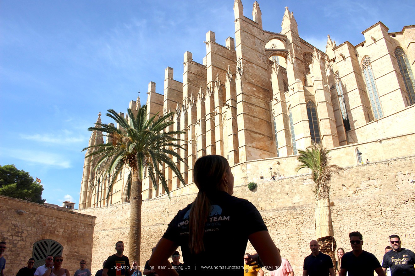 Event Manager leading the kick-off briefing in front of Palma Cathedral at Ses Voltes square during En Busca del Tesoro in Mallorca.