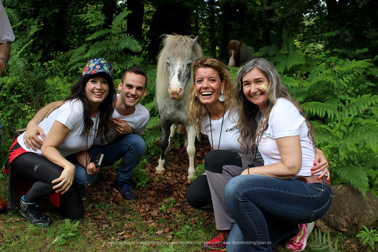 Participants smiling with a young foal in the Garrotxa Volcanic Zone Natural Park during En Busca del Tesoro in Girona.